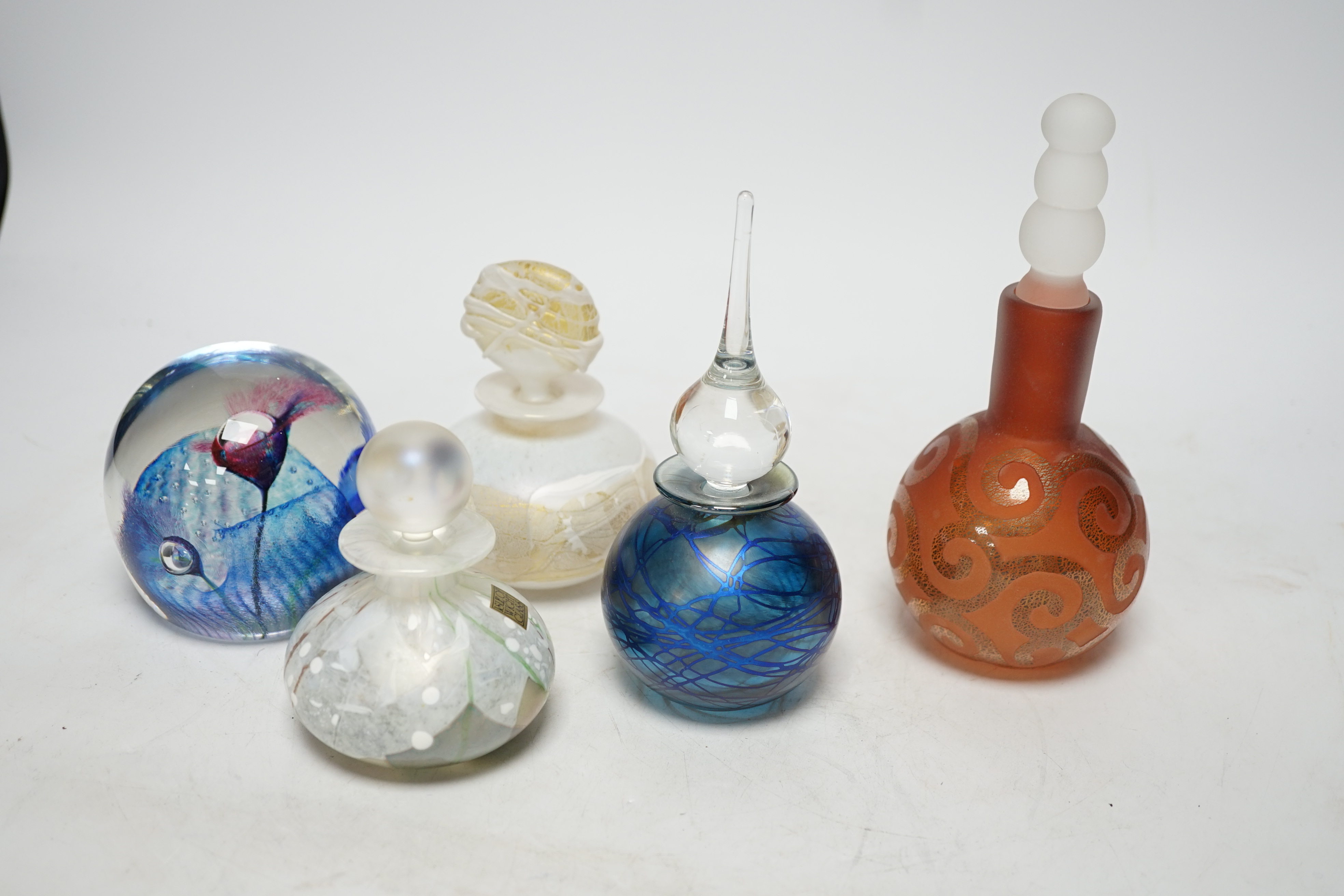 Four perfume bottles possibly by Blow Zone and paperweight by Helen Millard, tallest 17cm high
